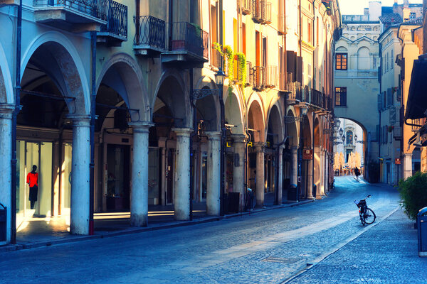 Bike on the street arcades in the early morning in Mantova with yellow facades. Italy