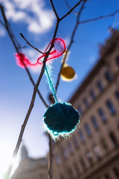 Bola brilhante de fio pendurado em um ramo na primavera — Fotografia de Stock