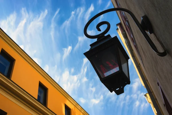 Уличный фонарь на фасаде здания на фоне клоу — стоковое фото