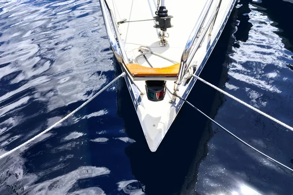 Neus jacht met touwen op het dock in het blauwe water — Stockfoto