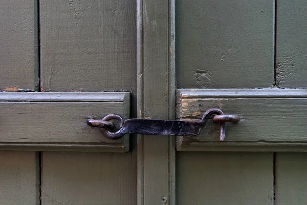 Forged steel hook on the green door — Stock Photo, Image