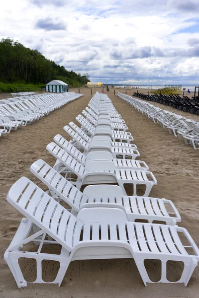 Row of white chairs for sunbathing on the sandy beach — Stock Photo, Image