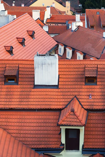 Красные черепичные крыши различных зданий в Праге — стоковое фото