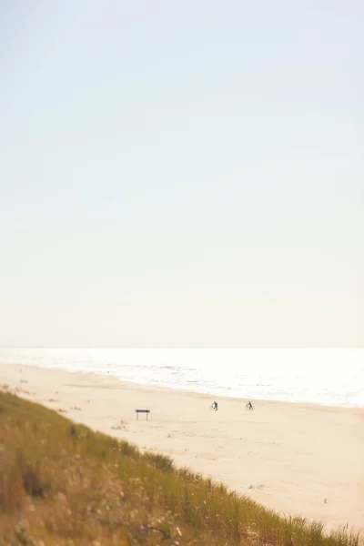 Twee fietsers op het strand in de buurt van de zee — Stockfoto