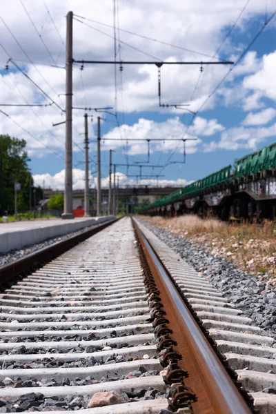 Rails et traverses ferroviaires avec nuages dans un ciel bleu vif — Photo