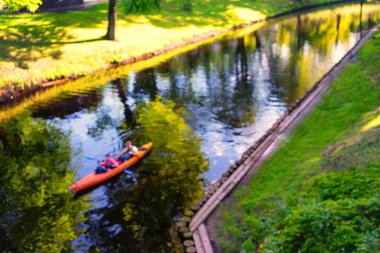 Çifti içinde yüzen bahar parkında kanoyla RI bulanık