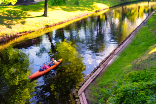 Çifti içinde yüzen bahar parkında kanoyla RI bulanık