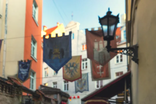 Alte Flaggen auf einer Straße in der Altstadt von Riga verschwimmen Frühling — Stockfoto