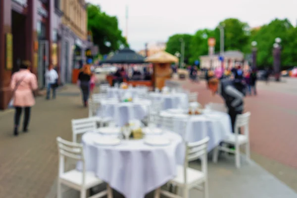 Mesa de restaurante com toalha de mesa branca e cadeiras na praça . — Fotografia de Stock