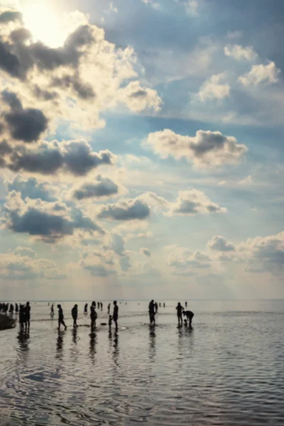 Silhouetten von Menschen, die im Meer gehen. verschwommen — Stockfoto