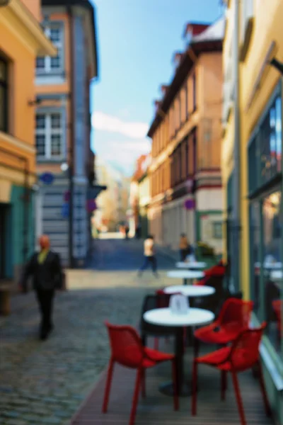 Café ao ar livre com cadeiras vermelhas no centro de Riga. Desfoque — Fotografia de Stock