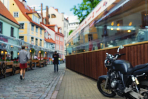 Motocykl v úzké uličce poblíž venkovních kaváren v Rize. BL — Stock fotografie