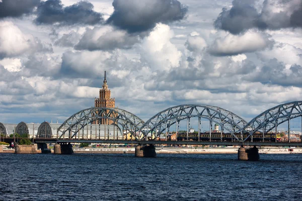 Ρίγα ανάχωμα στην γέφυρα στο ποταμό και σύννεφα καλοκαίρι — Φωτογραφία Αρχείου