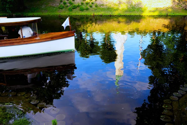 Туристы на лодке по городскому каналу с отражением — стоковое фото