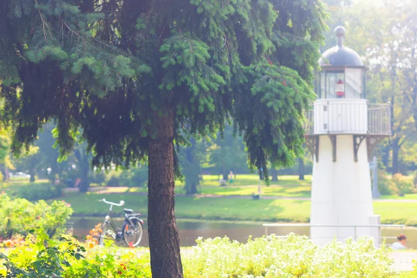 Stadspark met een vuurtoren op de gracht en fiets — Stockfoto