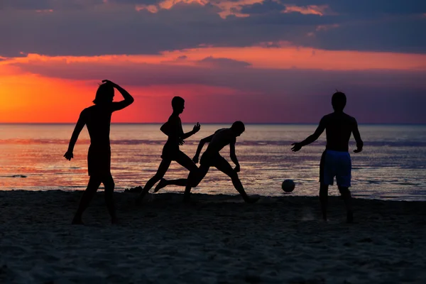 Silhuetas de futebolistas no pôr do sol — Fotografia de Stock