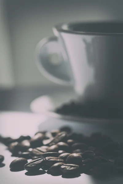 Coffee beans and a cup on the table. Blurry — Stock Photo, Image
