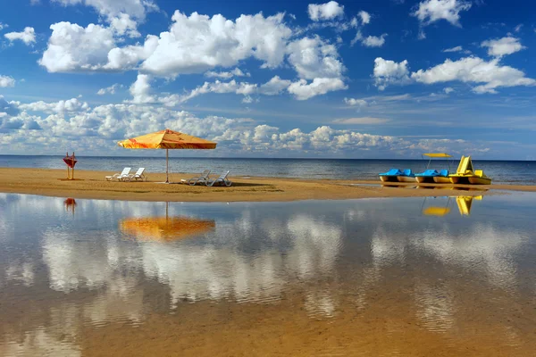 Hängematte mit Sonnenschirm und Liegestuhl am Strand mit Reflexion — Stockfoto