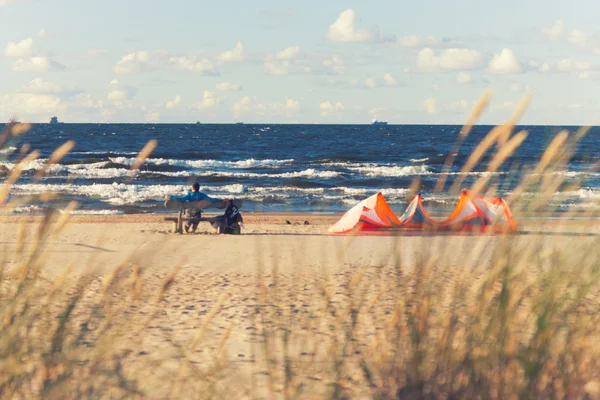 Mannen på stranden nära havet med en kite — Stockfoto