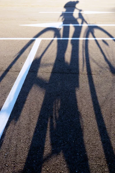 Stín cyklisty na chodníku směr šipky — Stock fotografie