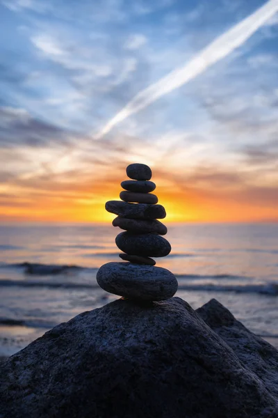 Stabiele verticale cairn bij zonsondergang op zee — Stockfoto