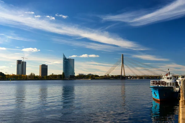 Barco azul no rio Daugava no fundo de uma suspensão — Fotografia de Stock