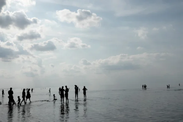 Tourists walk in the summer by the Baltic sea at low tide. Blurr — Stock Photo, Image