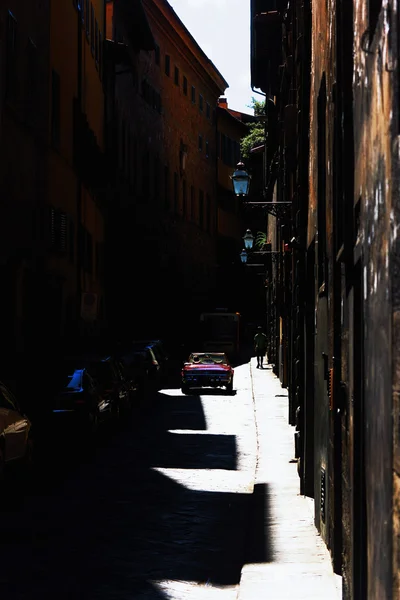 Les ombres des maisons dans une rue étroite avec des voitures en Italie — Photo