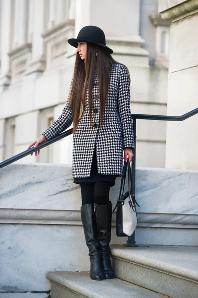 Élégante et à la mode jeune femme d'affaires debout à l'extérieur tenant un sac portant un chat et un chapeau noir — Photo