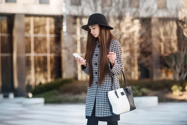 BBeautiful бізнес-леді, використовуючи смартфон і пішки біля офісної будівлі на міській вулиці — стокове фото