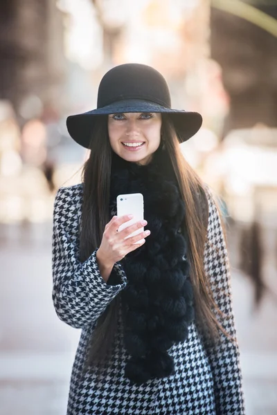 Beautiful fashionable business woman walking on city street and texting on mobile phone — Stock Photo, Image