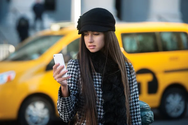 Hermosa mujer de negocios llamando al taxi usando el teléfono celular en la calle de la ciudad —  Fotos de Stock