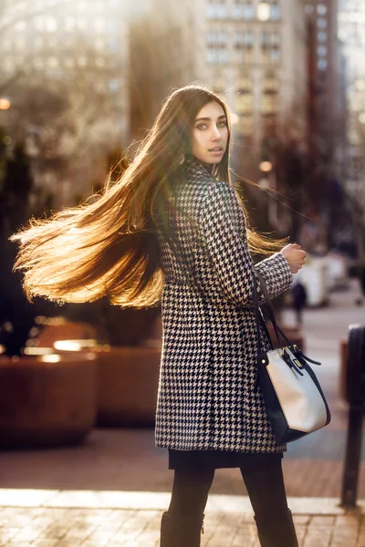 Mooie elegante brunette vrouw met lang haar wandelen in de stad — Stockfoto