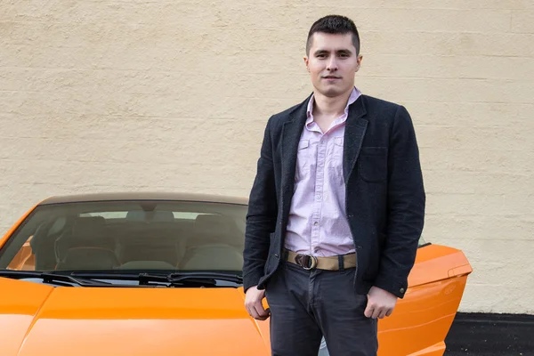 Joven hombre feliz de pie cerca de coche deportivo de lujo — Foto de Stock