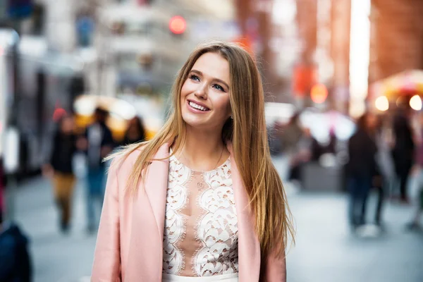 Happy smiling woman looking up and walking on city street — Stock Photo, Image