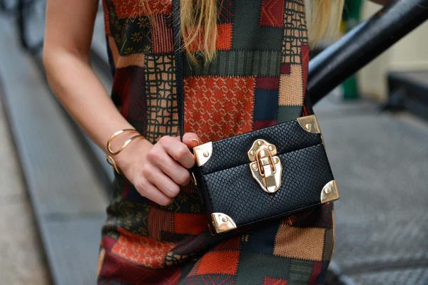 Black leather clutch bag and dress. Stylish women`s summer 2016 outfit. — Stock Photo, Image