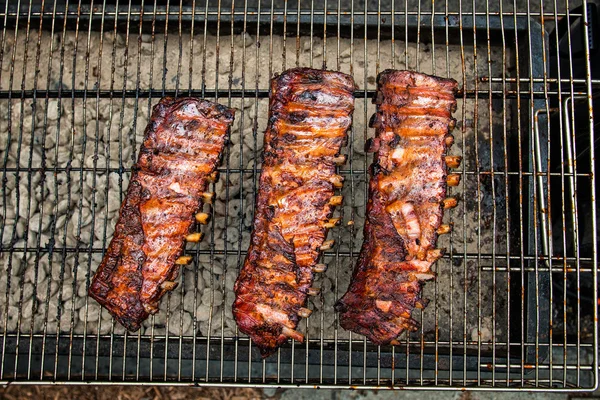 Costelas de porco fritas com molho de churrasco na grelha ao ar livre — Fotografia de Stock