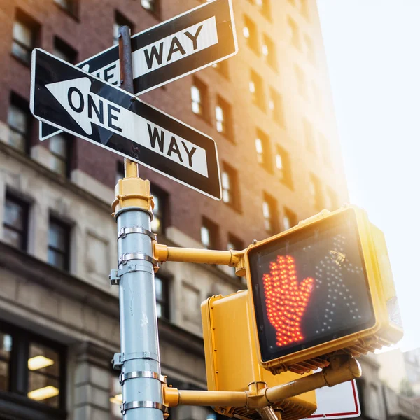 Señal de tráfico de la ciudad de Nueva York One Way con semáforo peatonal en la calle bajo la luz del atardecer. Ciudad urbana estilo de vida foto . —  Fotos de Stock