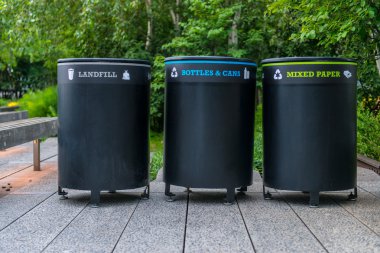 çöp konteynırları caddenin üzerinde. Üst üste ayrı çöp çöp toplama işaretleri ile renkli metal konteynerler