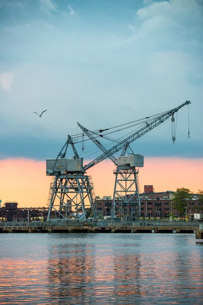 Vista da área industrial da cidade com guindastes portuários ao pôr do sol — Fotografia de Stock