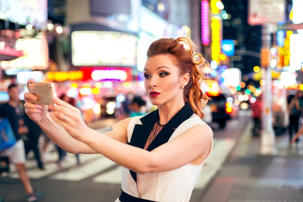 Frumoasă femeie turistică blogger de modă care face selfie fotografie pe timp de noapte Time Square din New York City — Fotografie, imagine de stoc