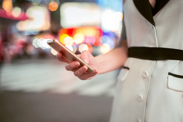 Close-up photo of business woman hand texting on cell phone at night New York City street. Businesswoman using mobile phone outdoors in nigh city. — Stock Photo, Image