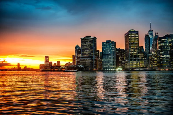 Vista panorámica del horizonte de Manhattan con hermosa luz del sol naranja del agua — Foto de Stock