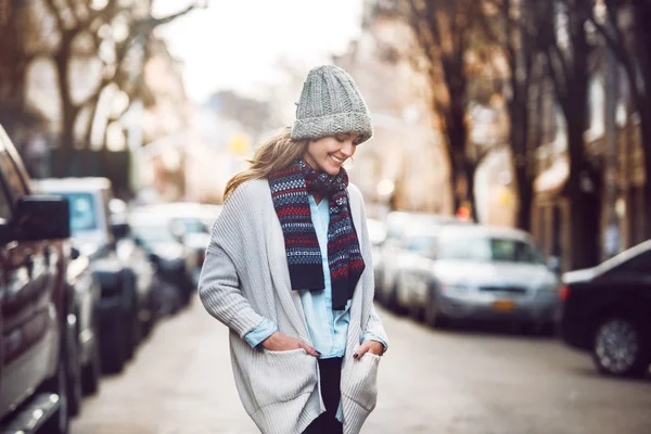 Gelukkig jong volwassen vrouw wandelen op mooie herfst stad straat dragen kleurrijke sjaal en warme muts — Stockfoto