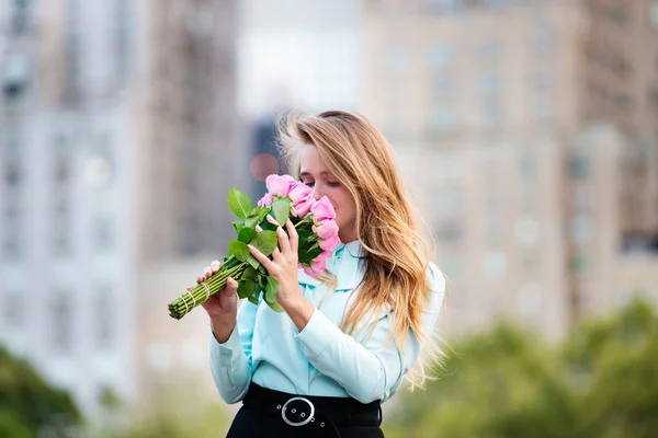 Elegante mooie jongedame ruiken roze roze bloem — Stockfoto