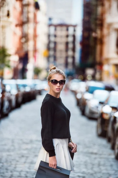 Mulher elegante lindo cruzando rua da cidade e levando sacos de compras. Conceito foto de Nova York compras no distrito de SoHo . — Fotografia de Stock