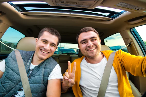 Happy friends ready for vacations driving car — Stock Photo, Image