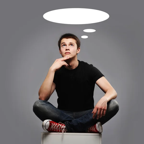 Young man sitting and thinking about something — Stock Photo, Image