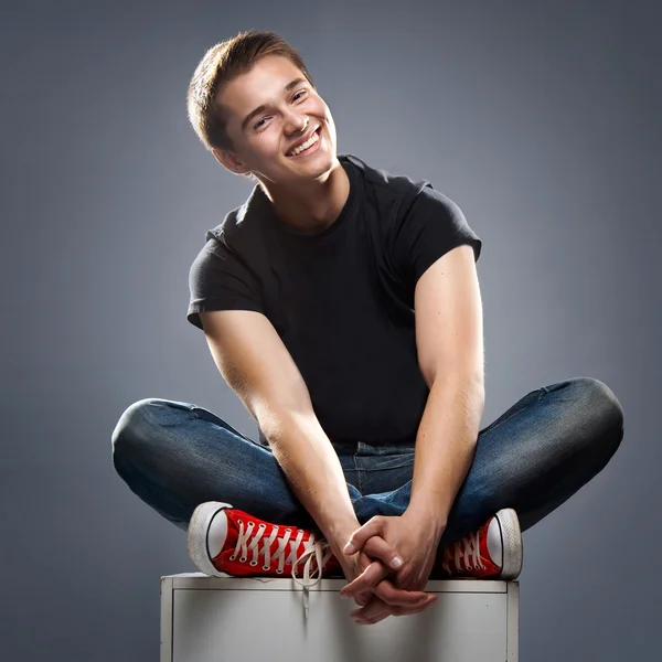 Portrait of handsome young man smiling isolated over grey — Stock Photo, Image