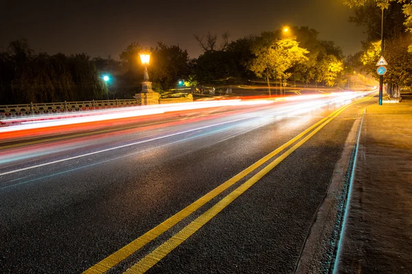 Carretera nocturna en la ciudad con coche los senderos ligeros — Foto de Stock